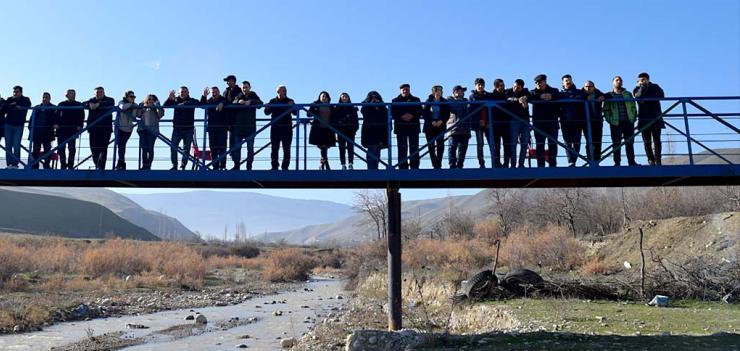 Before the bridge was built, makeshift wood planks and stones were used to help students cross.